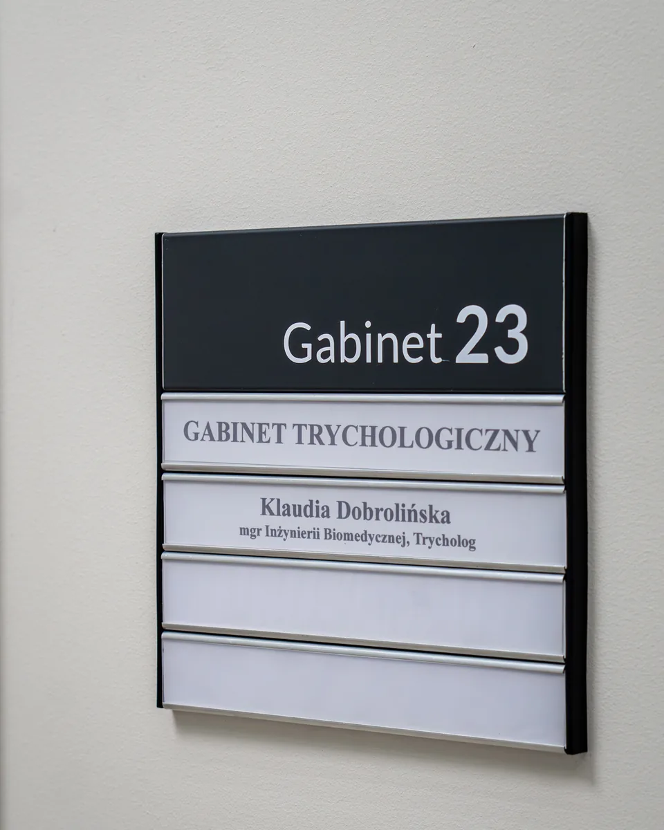 Tabliczka gabinetu trychologicznego Klaudii Dobrolińskiej, gabinet 23 przy Narutowicza 66 w Siedlcach